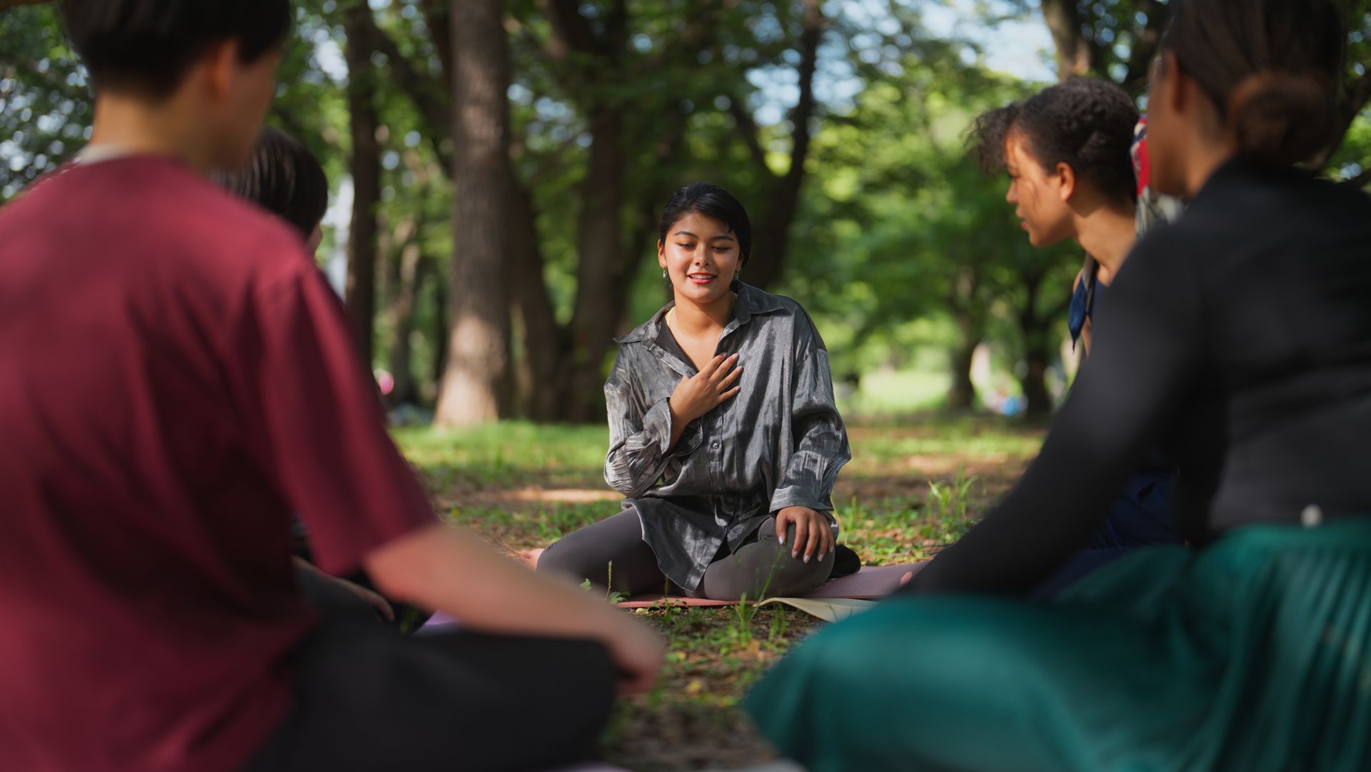 A young woman smiling during an outdoor group session in a park